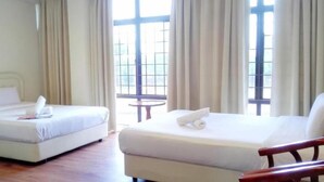 Two single beds with white linens and towels, a wooden floor, and large windows with curtains. - Sp Golden Star Hotel (Sungai Petani)