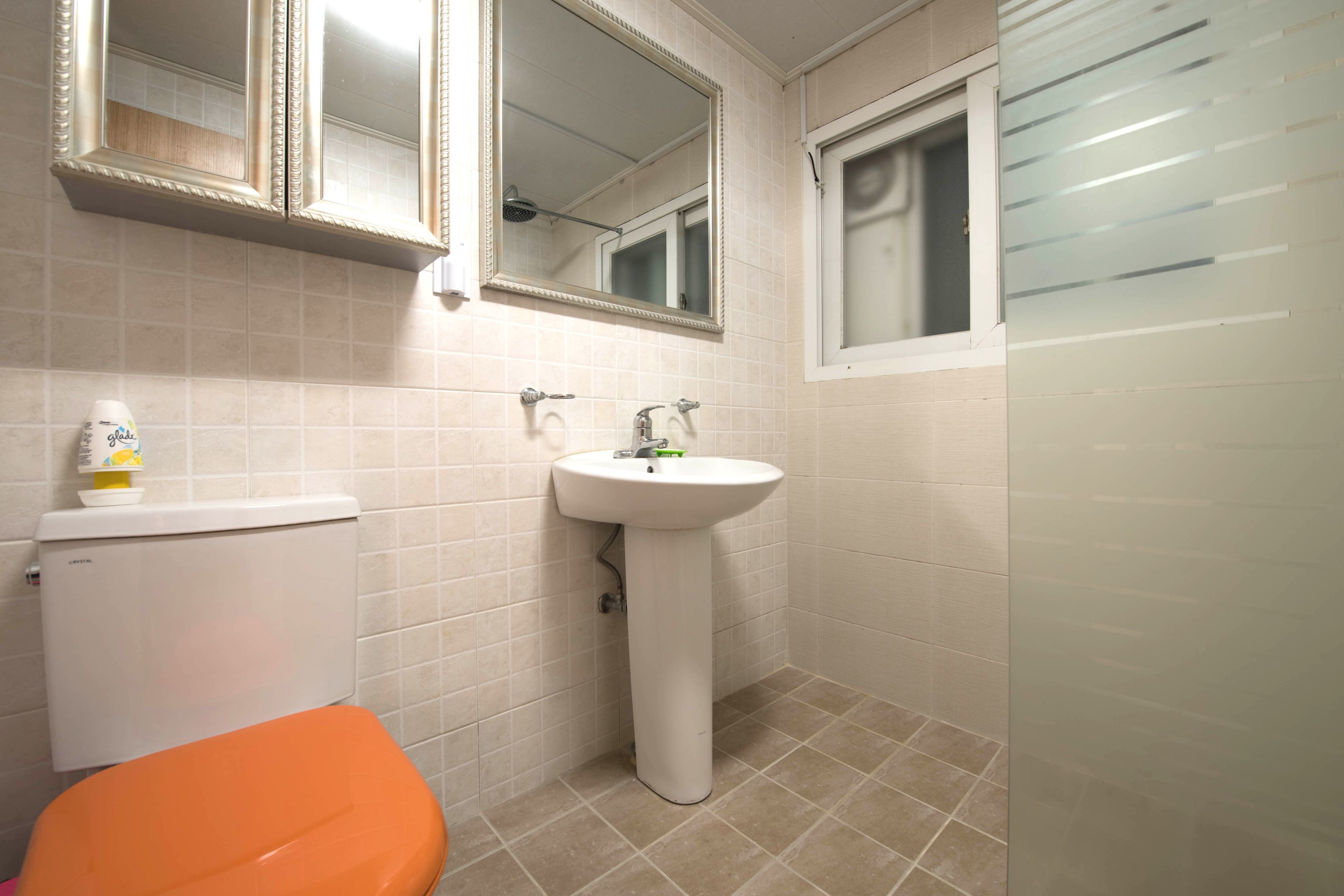 Un baño con inodoro, lavabo y espejos.
