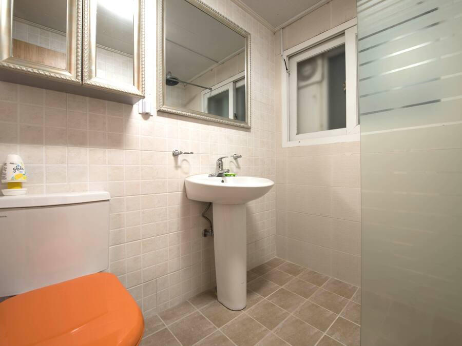 Un baño con inodoro, lavabo y espejos.