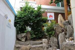 A stone staircase leading up to a building with a sign reading "Hongdae Style Guest House."