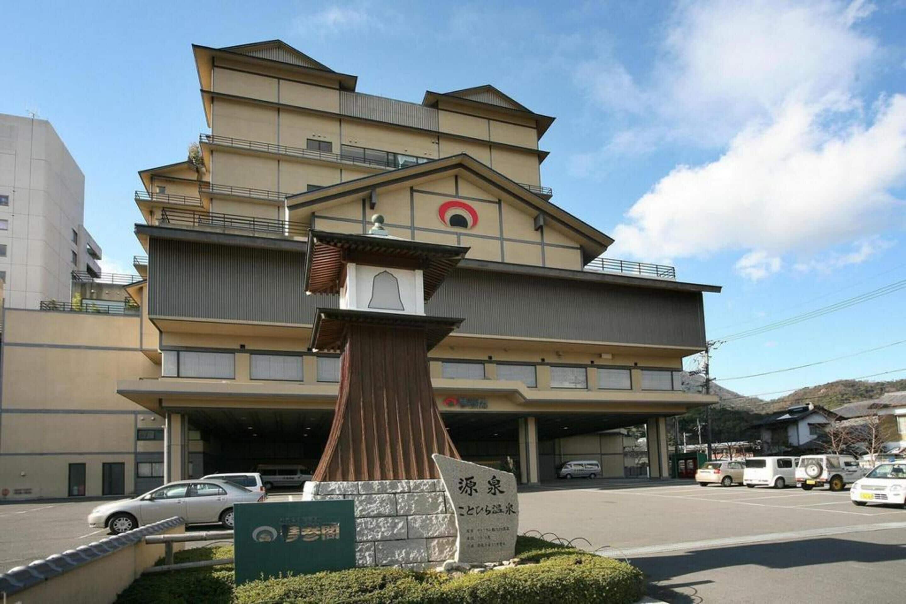 A multi-story building with a prominent entrance and a sign indicating a hotel.