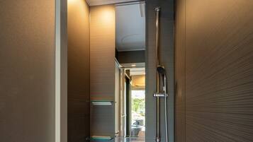 A modern bathroom with a glass shower enclosure, a mirror, and a towel rack.
