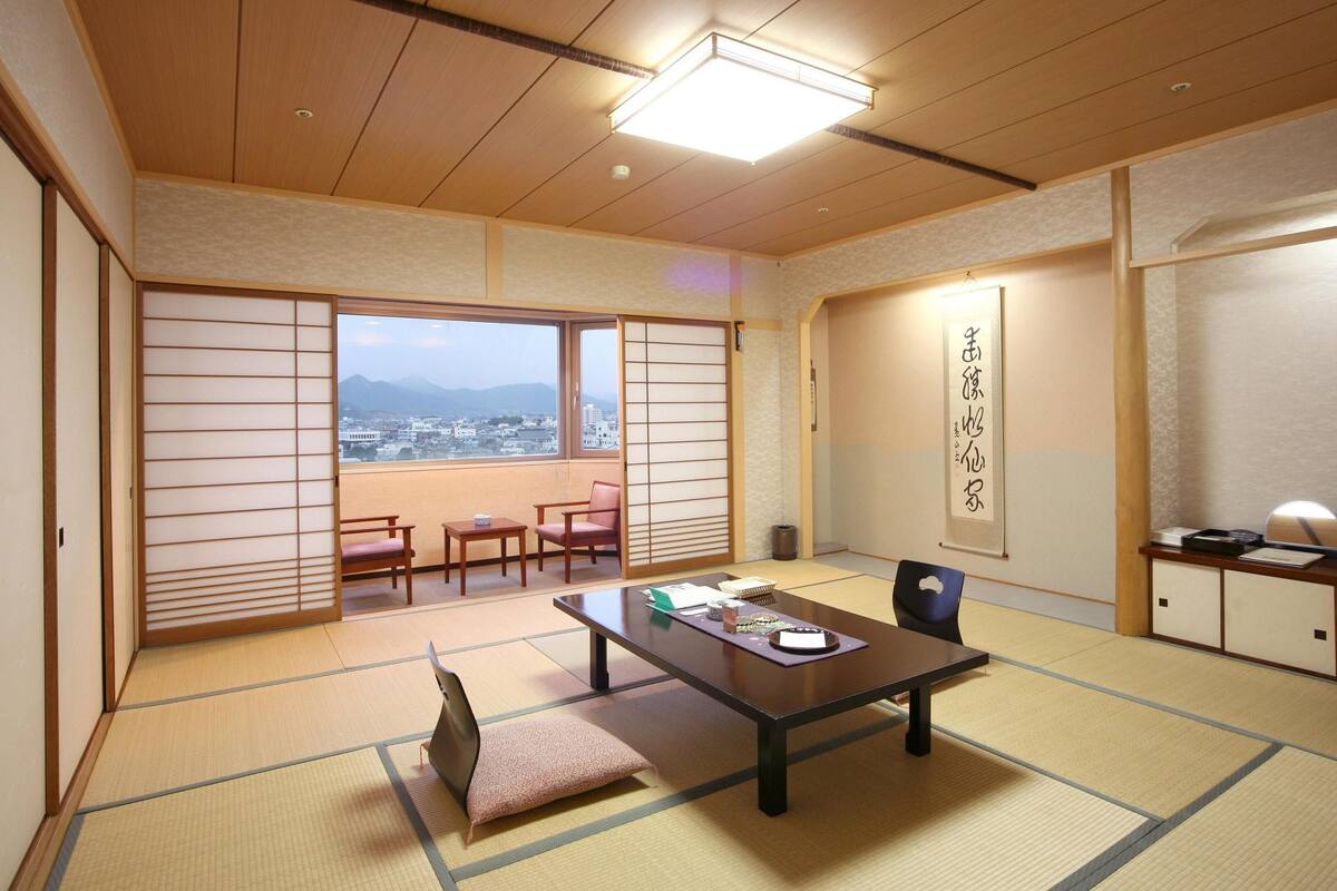 Ein traditioneller japanischer Raum mit Tatami-Böden, einem niedrigen Tisch und Schiebetüren.