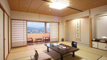 Una habitación japonesa tradicional con suelo de tatami, una mesa baja y puertas correderas.