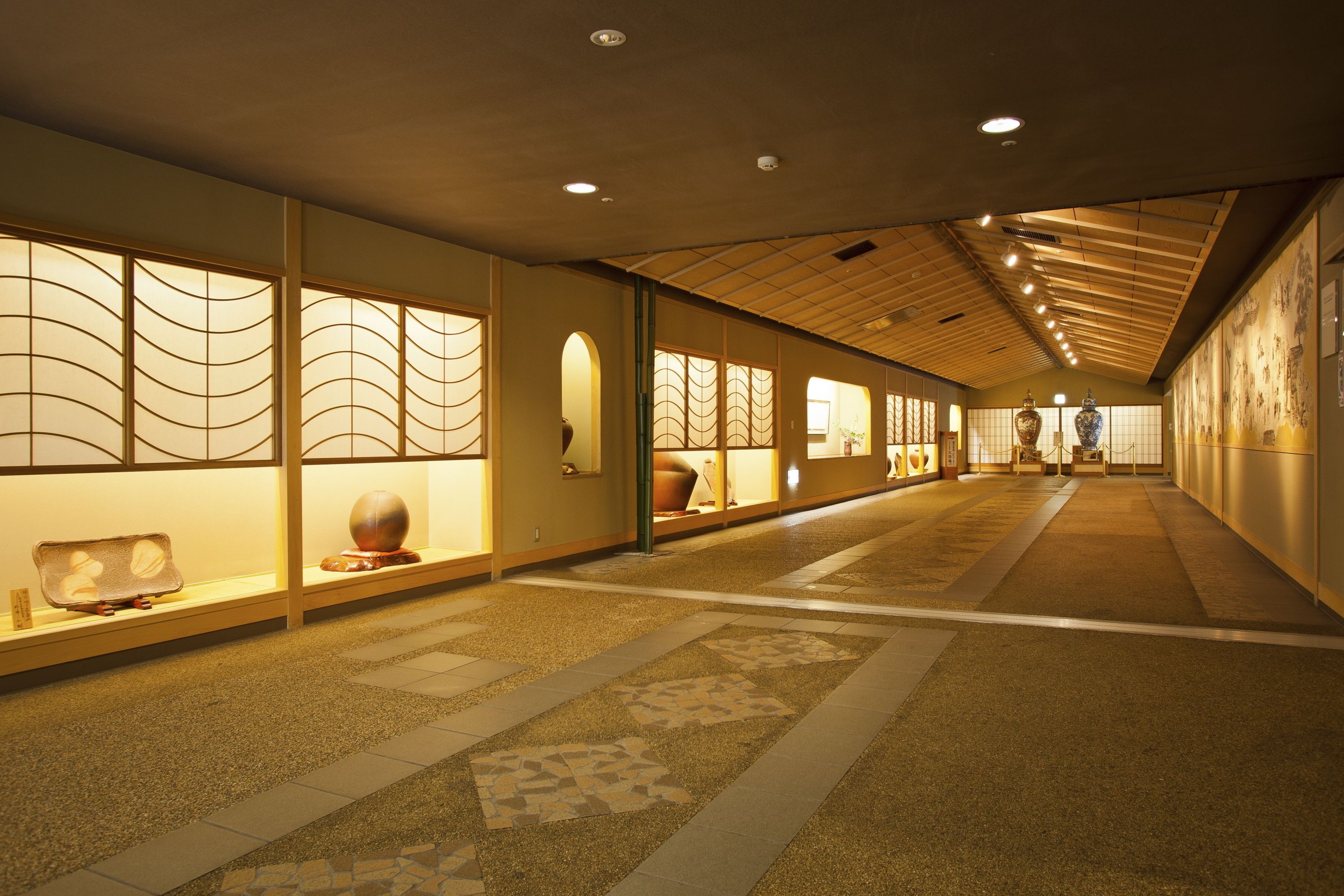 Un couloir décoré dans le style traditionnel japonais, avec des portes coulissantes et un sol orné de motifs.