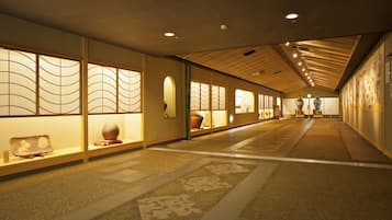 Un couloir décoré dans le style traditionnel japonais, avec des portes coulissantes et un sol orné de motifs.