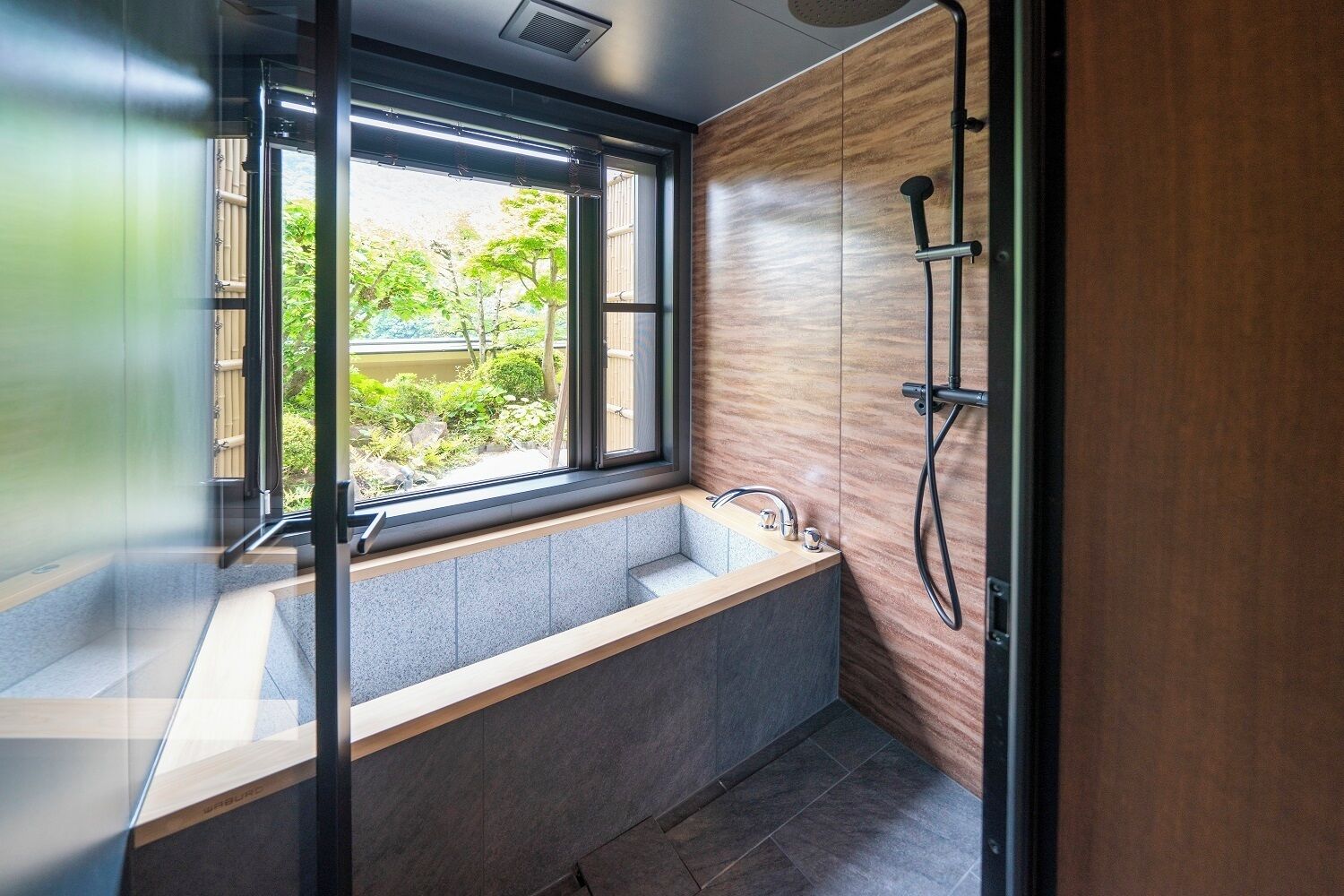 A modern bathroom with a built-in window, a shower, and a sink.