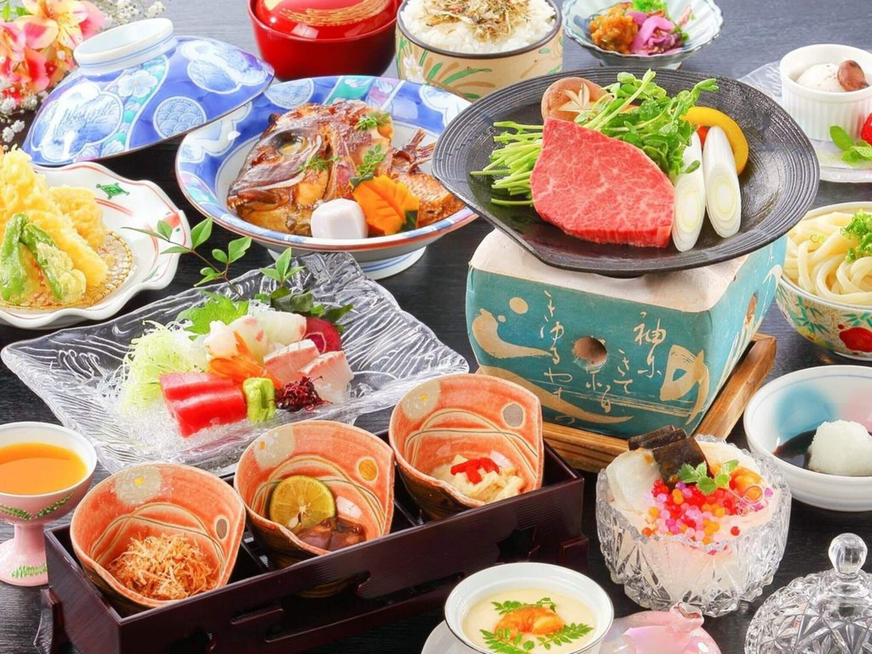 A variety of Japanese dishes including sushi, sashimi, and other seafood delicacies, presented on traditional ceramic and glassware.