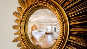 Een slaapkamer met een groot bed, een nachtkastje en een stoel.