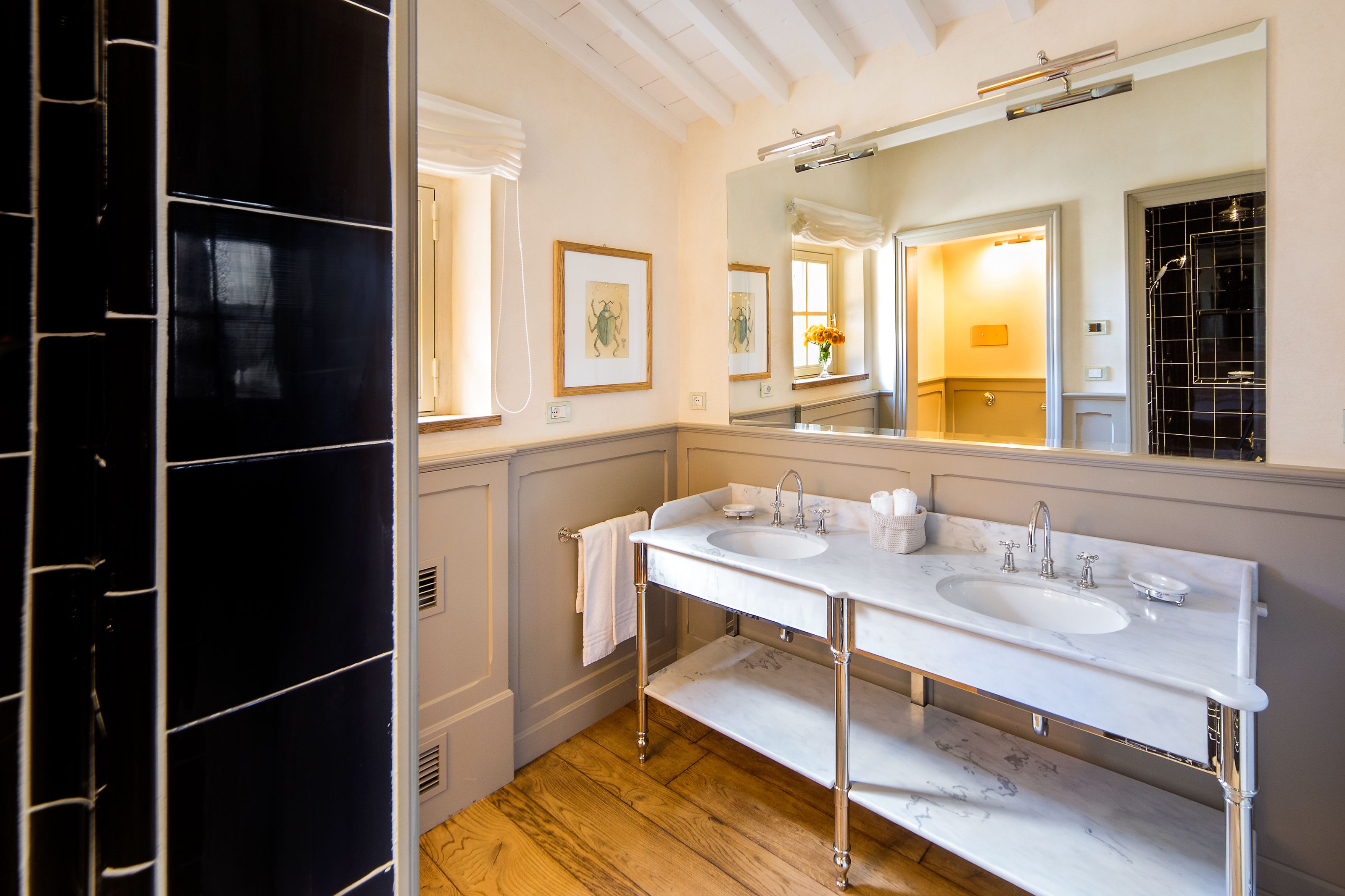 Une salle de bain avec deux lavabos, un grand miroir et un plancher en bois.