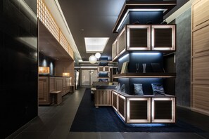 Un interior moderno con un pasillo central, estanterías de madera e iluminación empotrada en el techo.