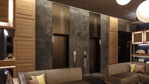 Un interior moderno con un sofá modular, paneles de madera y una pared de acento oscura.