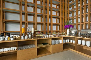 A buffet setup with various food items, utensils, and a coffee station. - Da Nang Bay Hotel (Da Nang)
