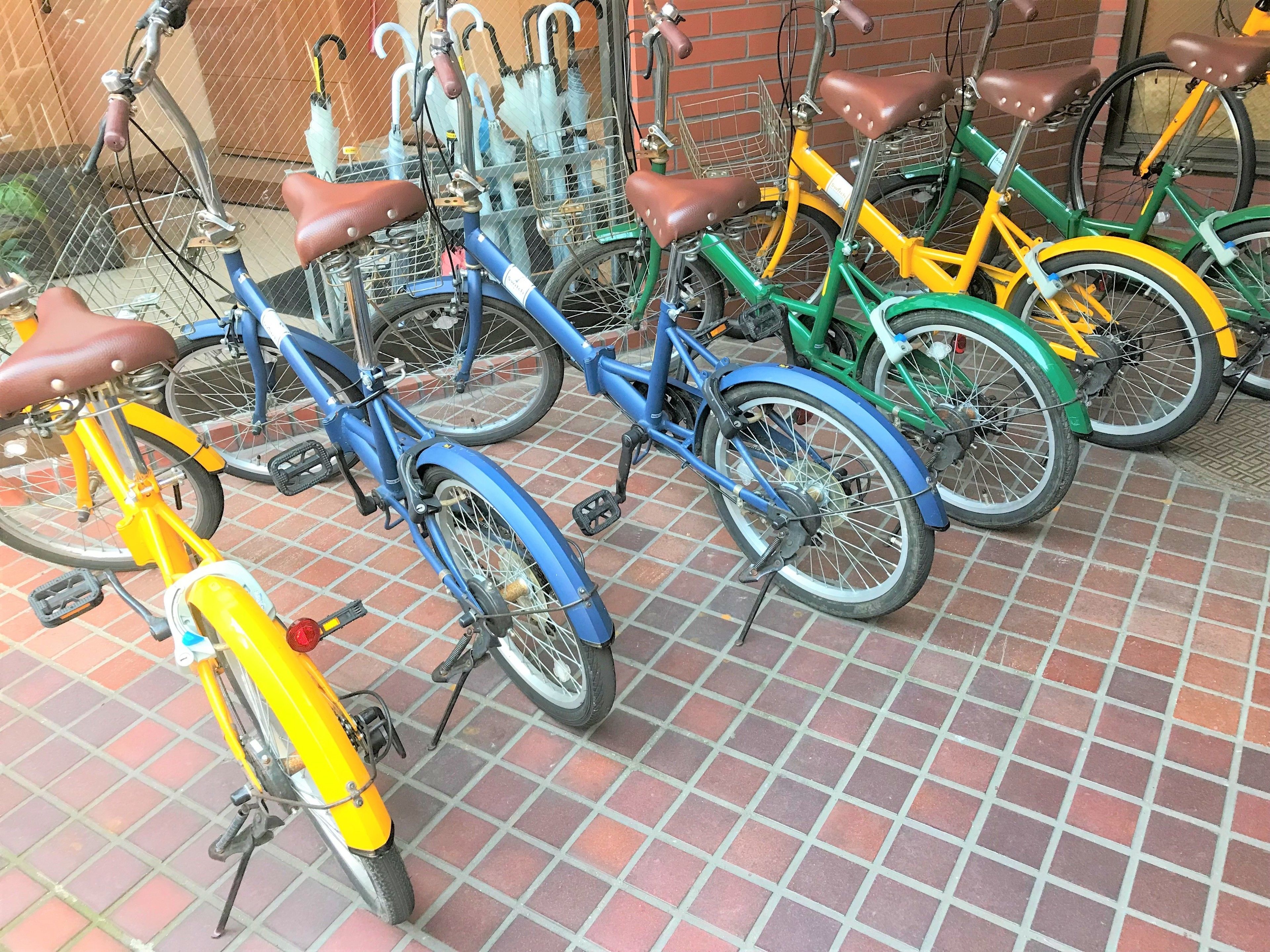 A row of bicycles parked on a tiled surface.