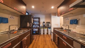 A modern kitchen with two sinks, wooden cabinets, and a microwave.