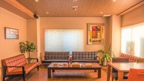 A modern living room with a sofa, a coffee table, and a dining area.