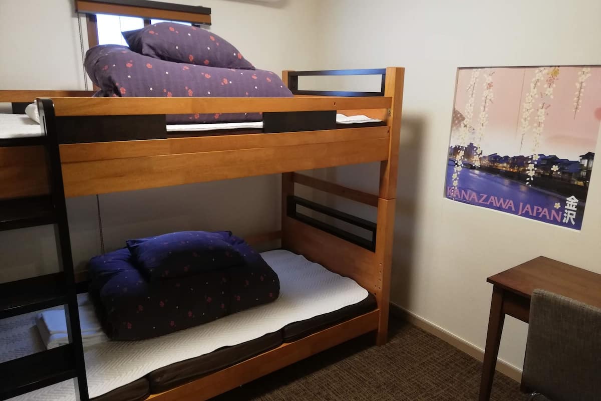 Ein Mehrbettzimmer mit einem Poster von Kanazawa, Japan, an der Wand.