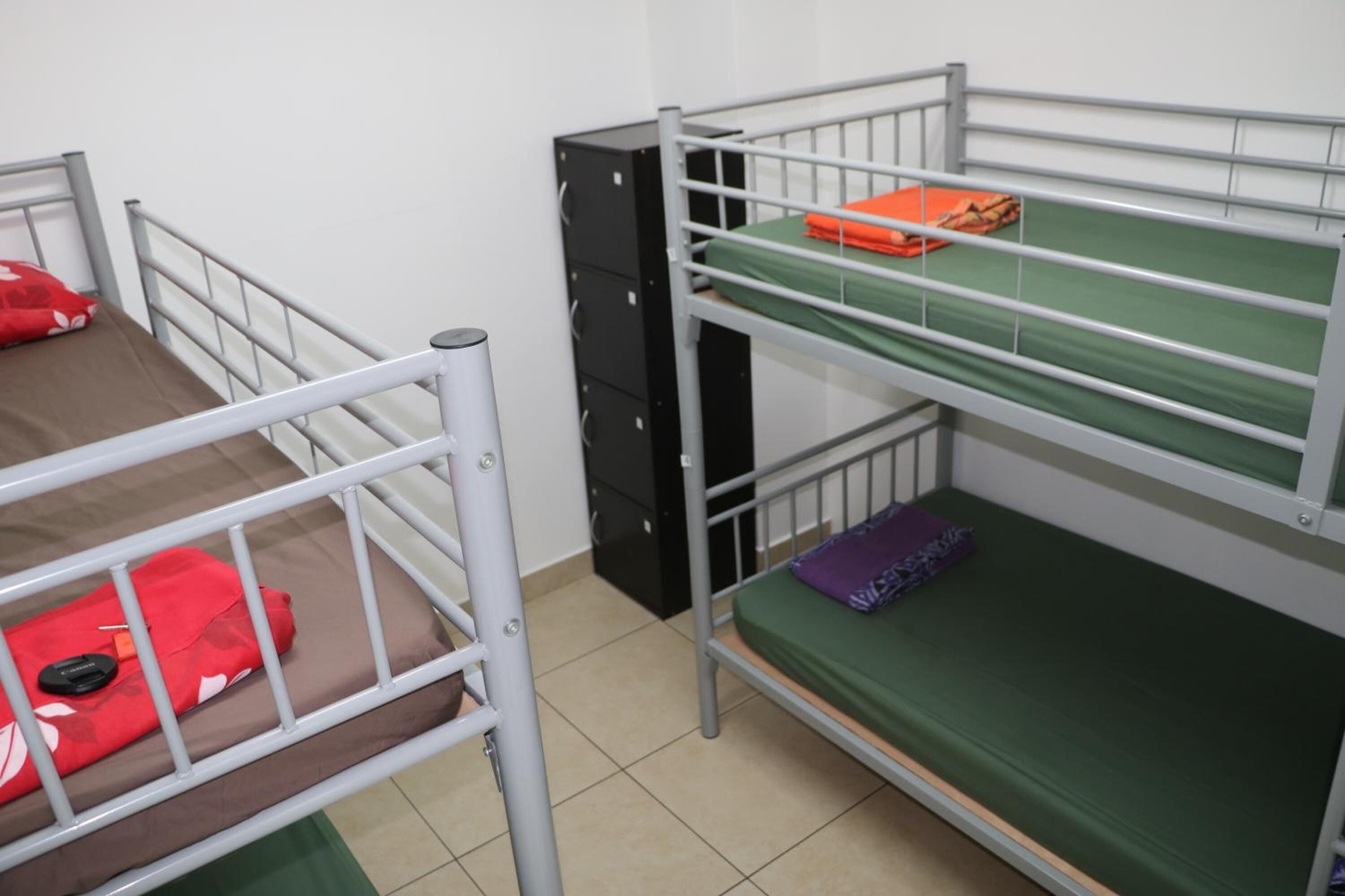 Ein Schlafsaalzimmer mit Etagenbetten, einem Schreibtisch und einem Kleiderschrank.