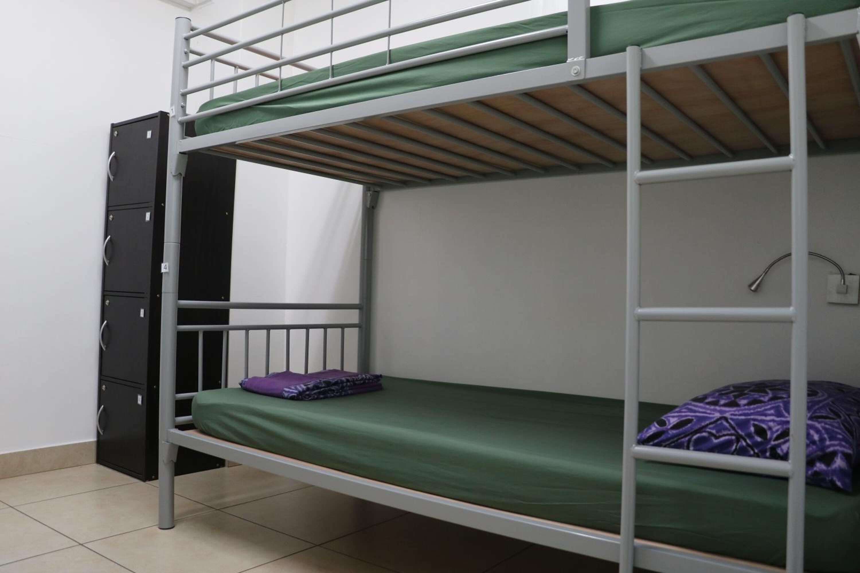A bunk bed room with a desk and a filing cabinet.