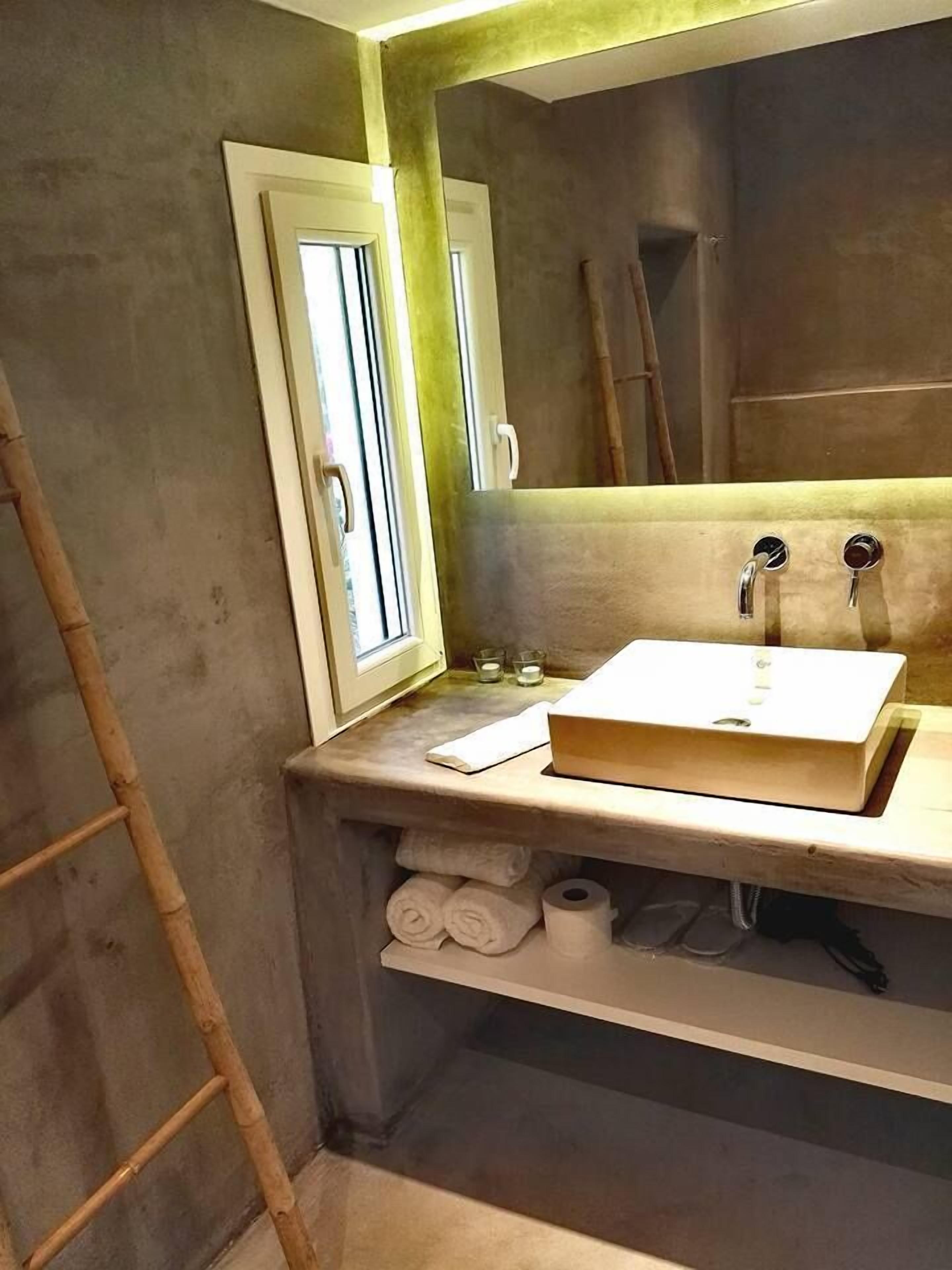A bathroom with a white sink, a mirror, and a towel rack.