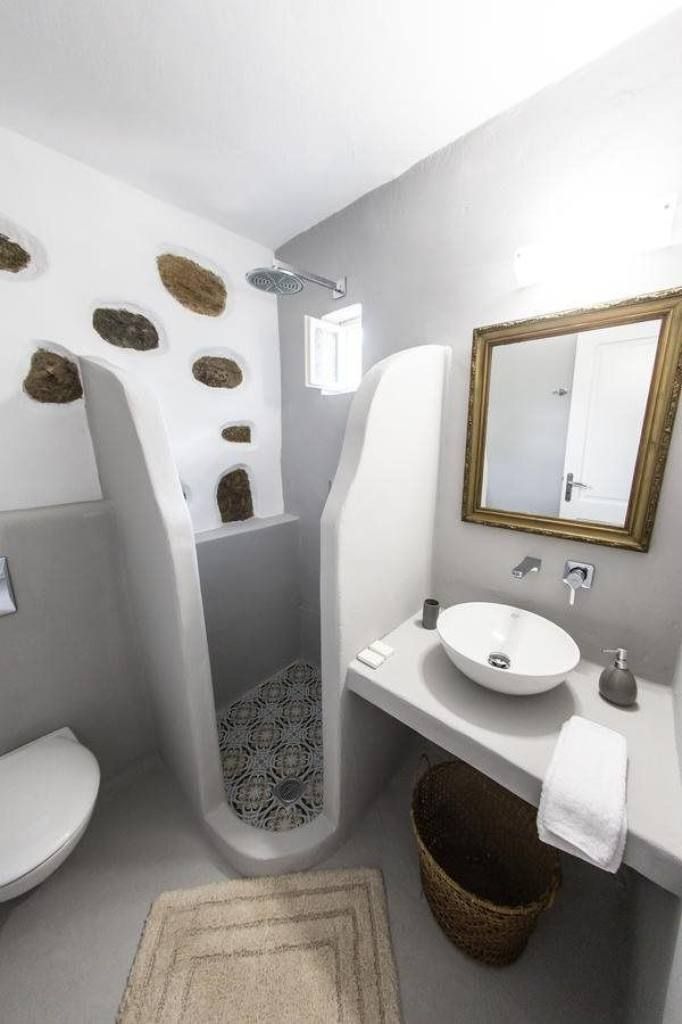 A modern bathroom with a white sink, a mirror, and a toilet.