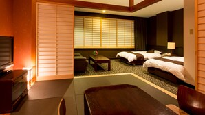 A hotel room with a sofa, a bed, a desk, and a TV.