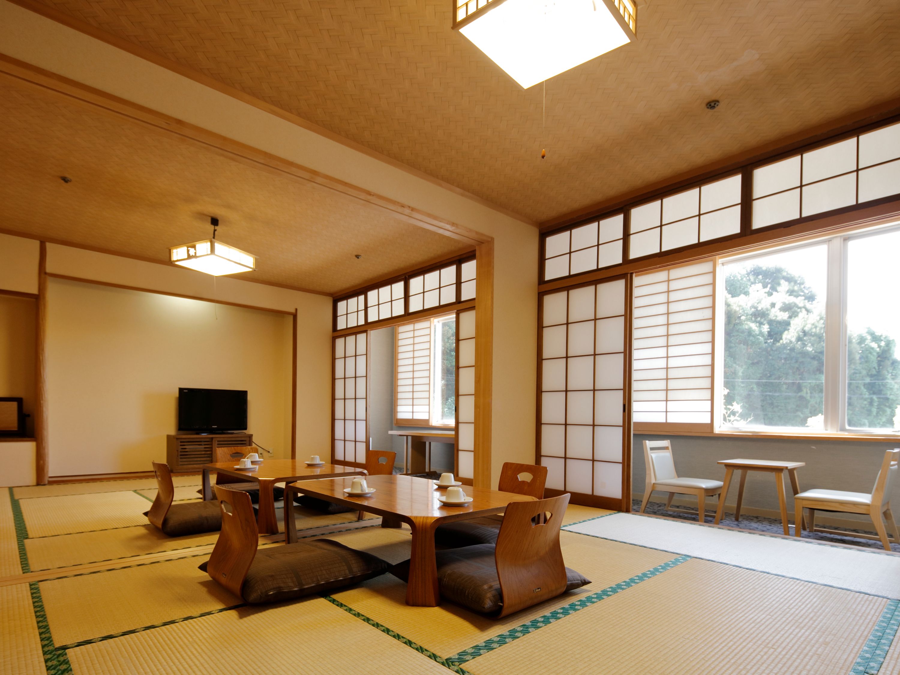 A traditional Japanese room with tatami flooring, a low table, and sliding doors.
