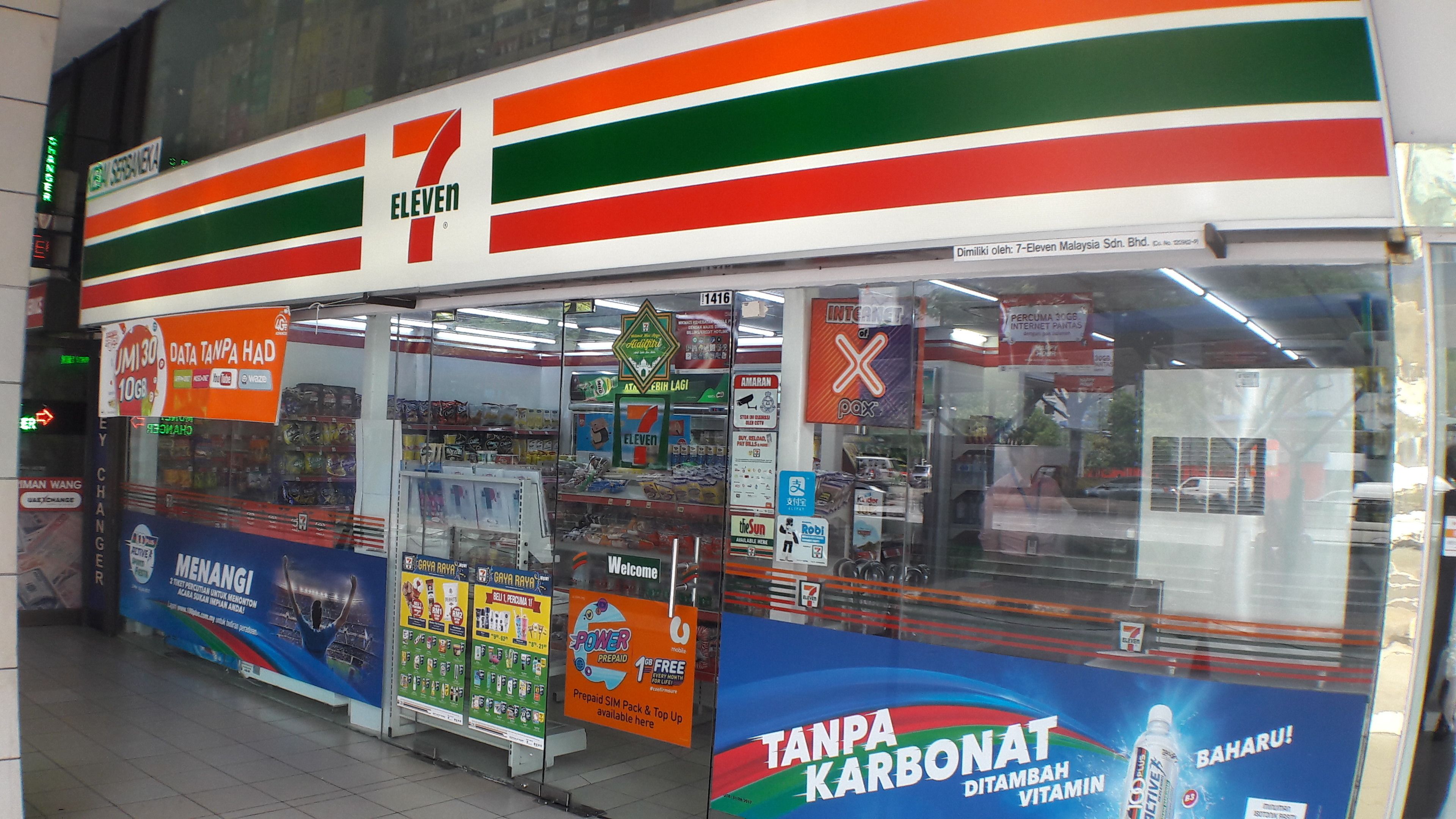 A 7-Eleven convenience store with various advertisements and products displayed.