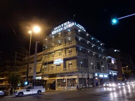 Monikerroksinen hotelli, jonka julkisivussa on suuri, selkeästi näkyvä kyltti, jossa lukee: ”HOTEL ATHENS LYDIA”.
