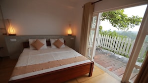 A bedroom with a large bed, two bedside lamps, and a view of a balcony with a white fence. - Villa Perpetua (Bandarawela)
