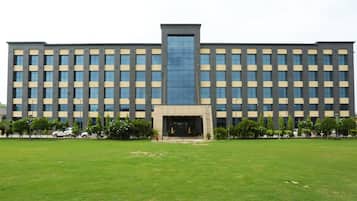 A large, modern building with a symmetrical facade, multiple windows, and a central entrance.