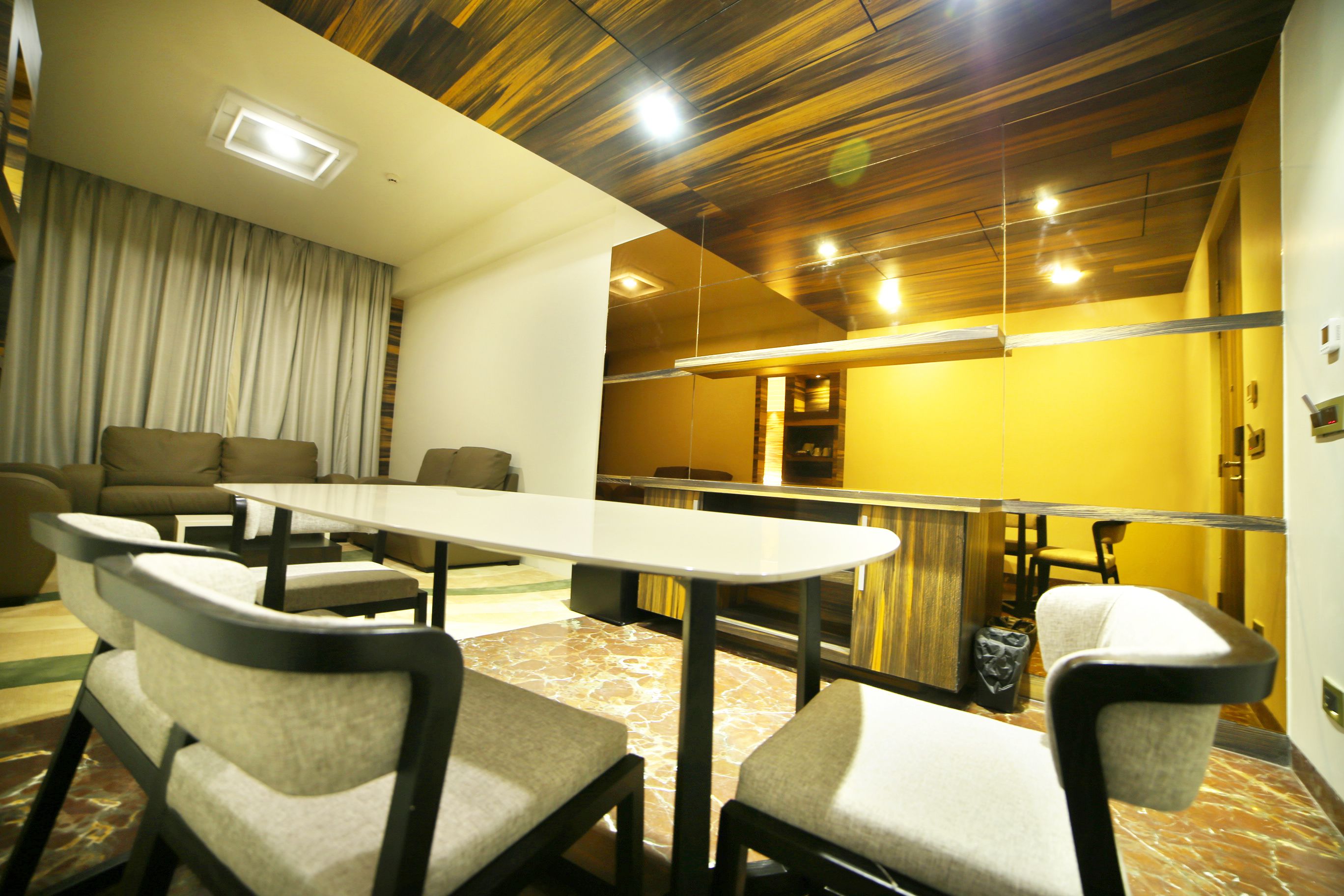 Una habitación de hotel moderna con comedor, sofá y mesa.