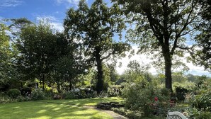 A garden with a stone pathway, a bench, and a lawn. - Ballylagan Organic Farm (Ballyclare)