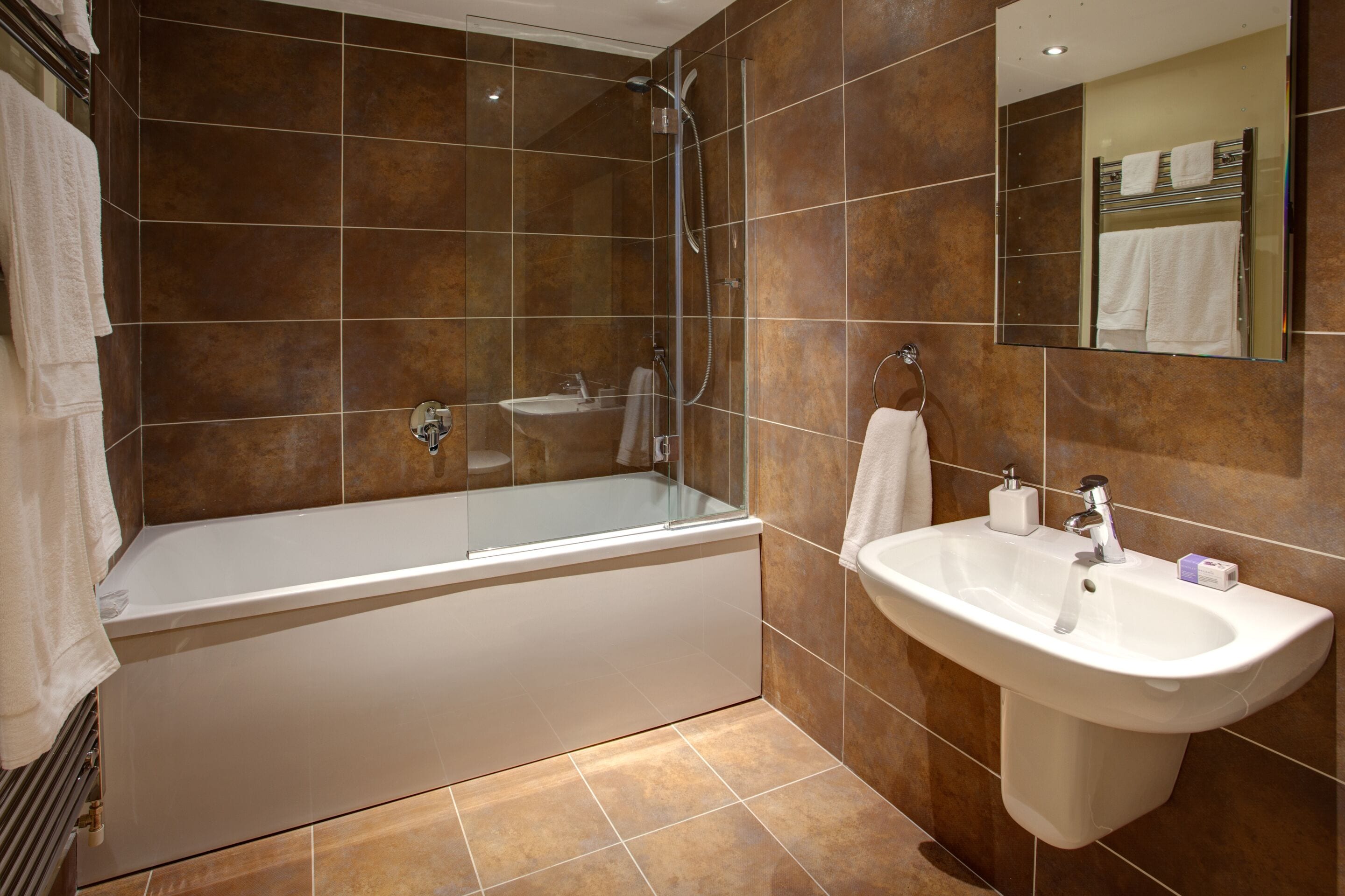 A modern bathroom with a bathtub, a sink, and a shower.