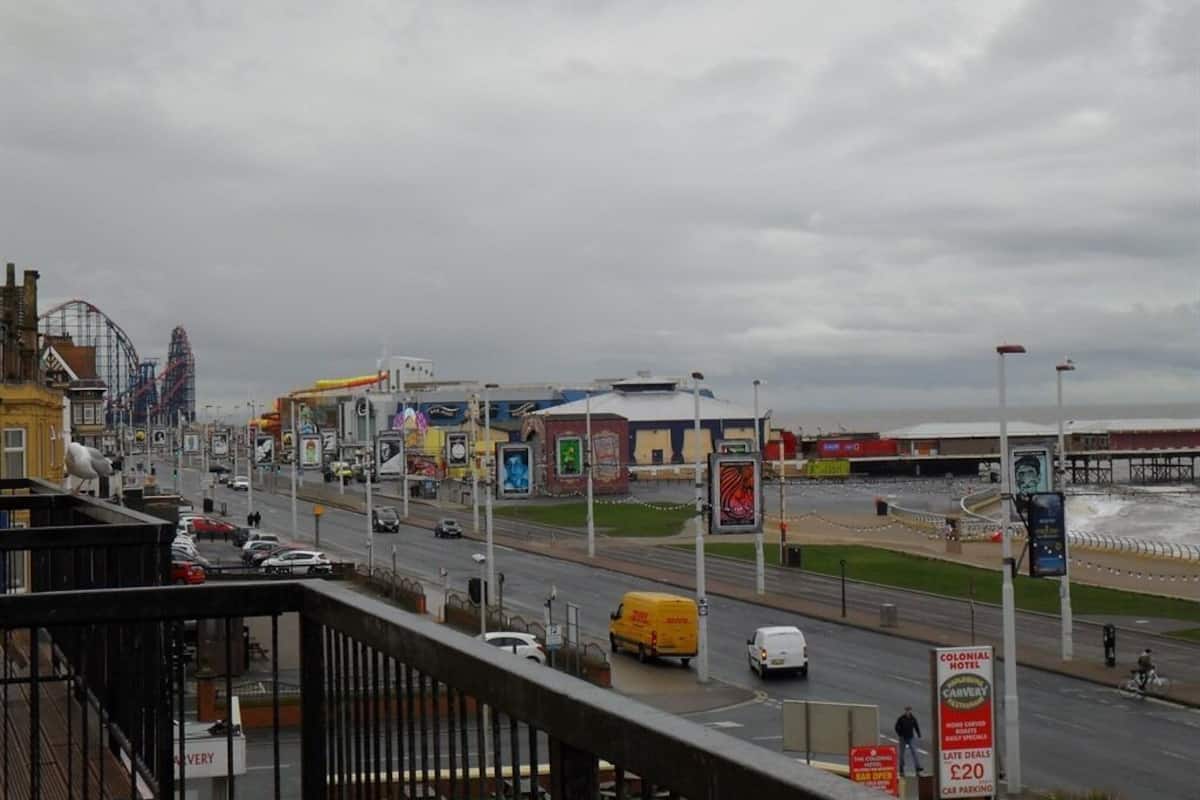 A coastal cityscape with a prominent hotel sign advertising late deals and car parking.