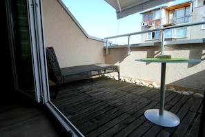A balcony with a wooden floor, a metal table, and a chair. - Baratero Terrasse Apartment (Sofia)