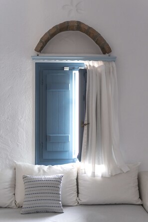A room with a blue door, white curtains, and a white wall. - Kalderimi (Astypalaia)