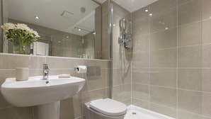 Une salle de bain moderne avec un lavabo, des toilettes et une douche.