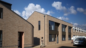 Un bâtiment moderne avec une façade en briques, de grandes fenêtres et un ciel dégagé.