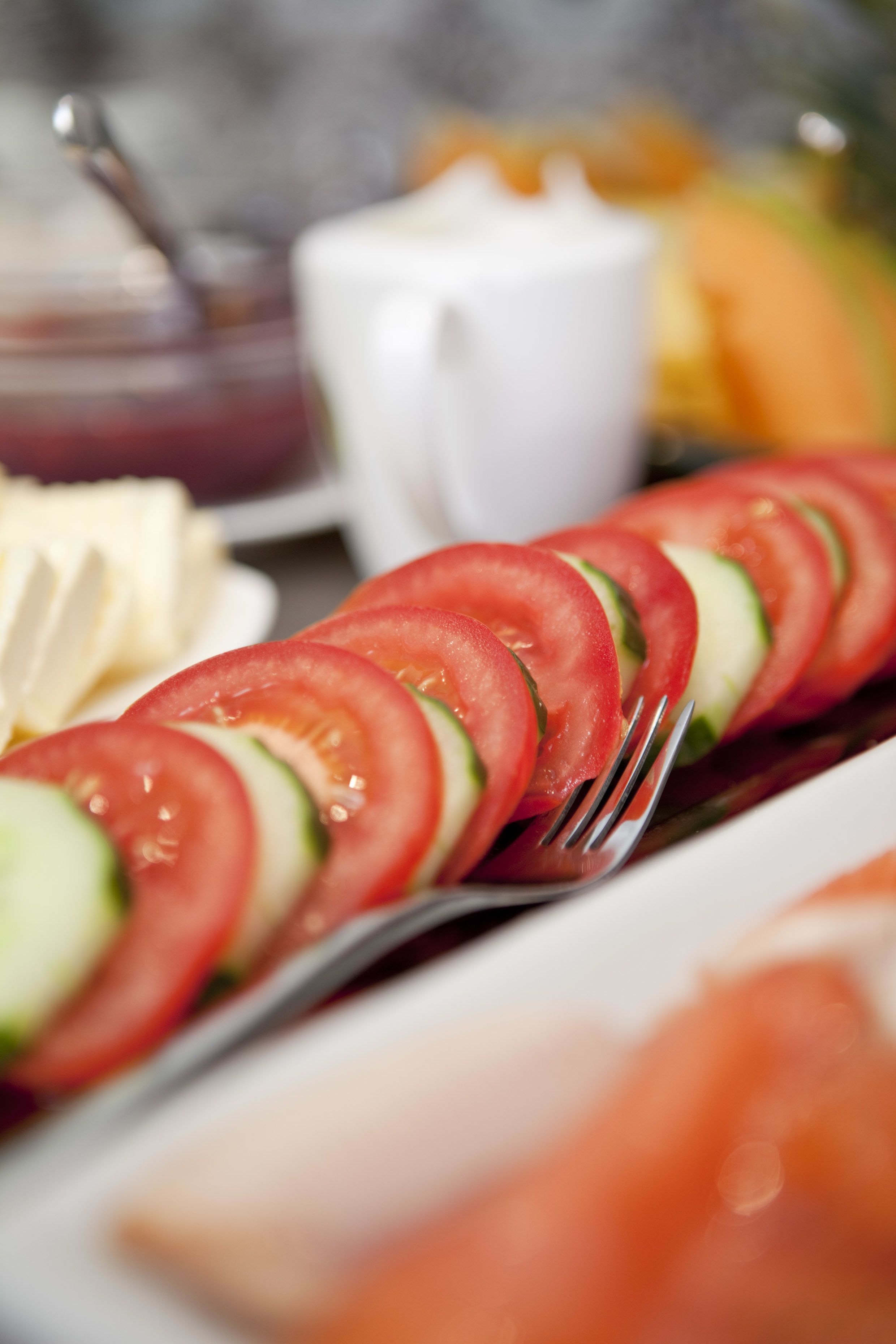 A close-up of a salad with sliced tomatoes and cucumbers on a plate.