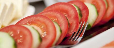 A close-up of a salad with sliced tomatoes and cucumbers on a plate.