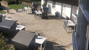A thatched-roof building with outdoor seating and a view of the countryside. - Strandvogtei Sylt (Sylt)