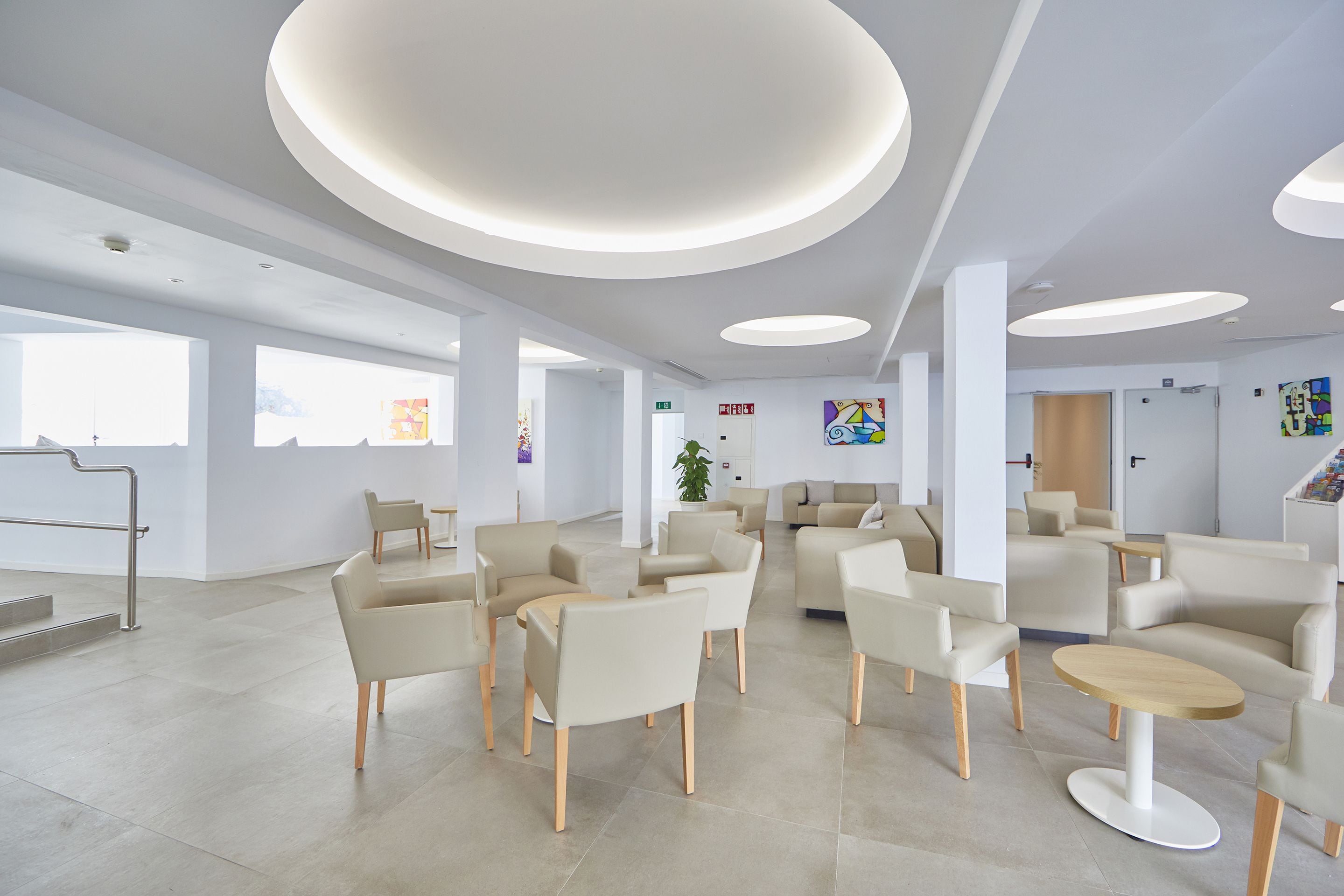 Eine geräumige Lobby mit moderner Einrichtung, großen Fenstern und einem klaren, minimalistischen Design.