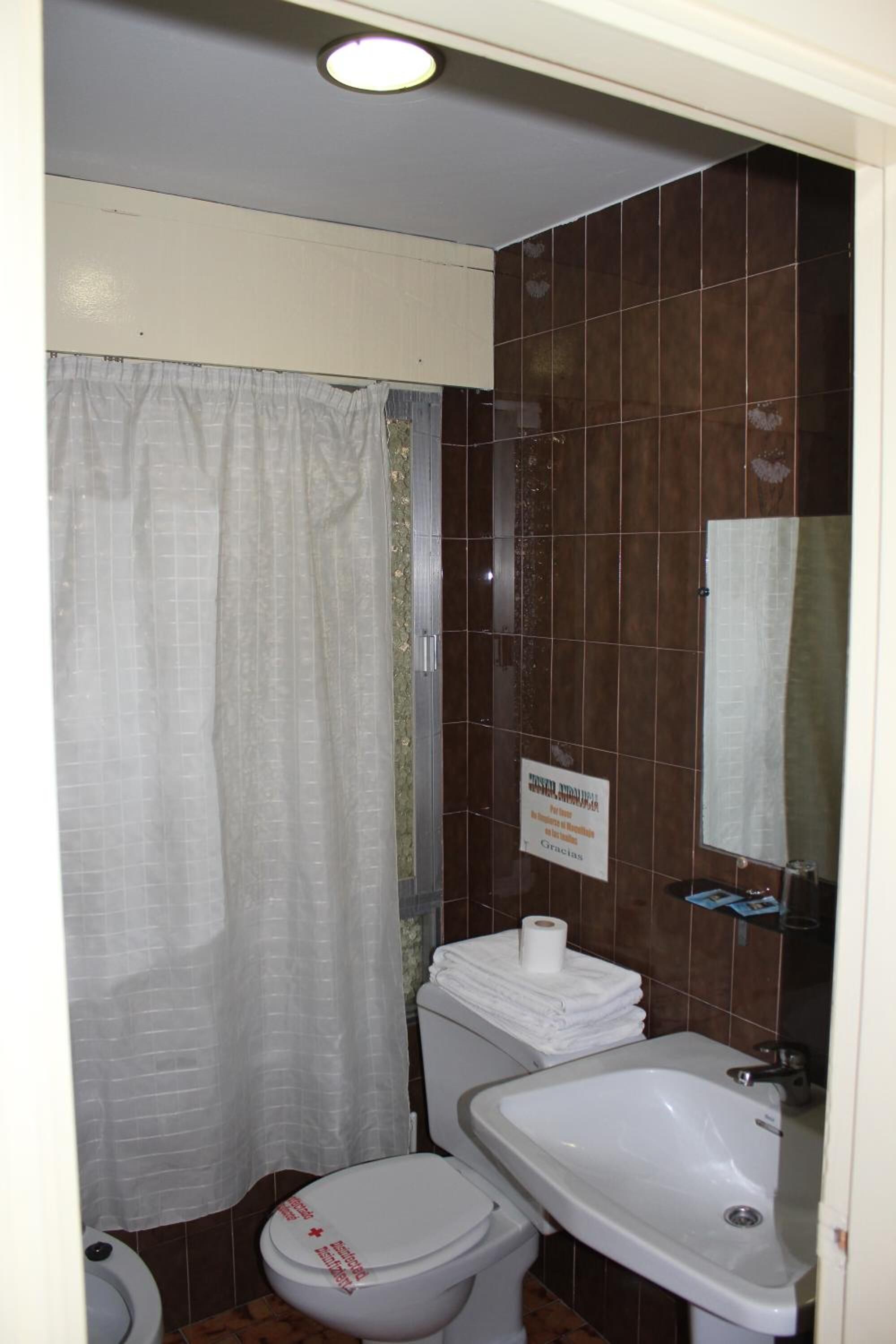 Ein kleines Badezimmer mit Toilette, Waschbecken und Duschvorhang.