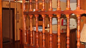 A wooden staircase with a balustrade leading to a room with a desk and a lamp. - Hostal Andalucía (Almunecar)