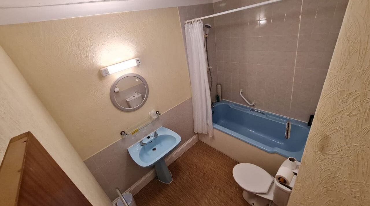 Een badkamer met een wastafel, toilet en bad.