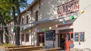 A building with outdoor seating and a sign reading "BrauTube". - TRIO Apartment Hotel Berlin (Berlin)