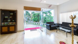 Amplia sala de estar con puerta de cristal que da a un balcón, un sofá, una mesita de centro y una lámpara decorativa.