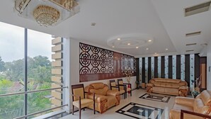 Un salón espacioso con un ventanal grande, dos sofás, una mesita de centro y un panel decorativo en la pared.