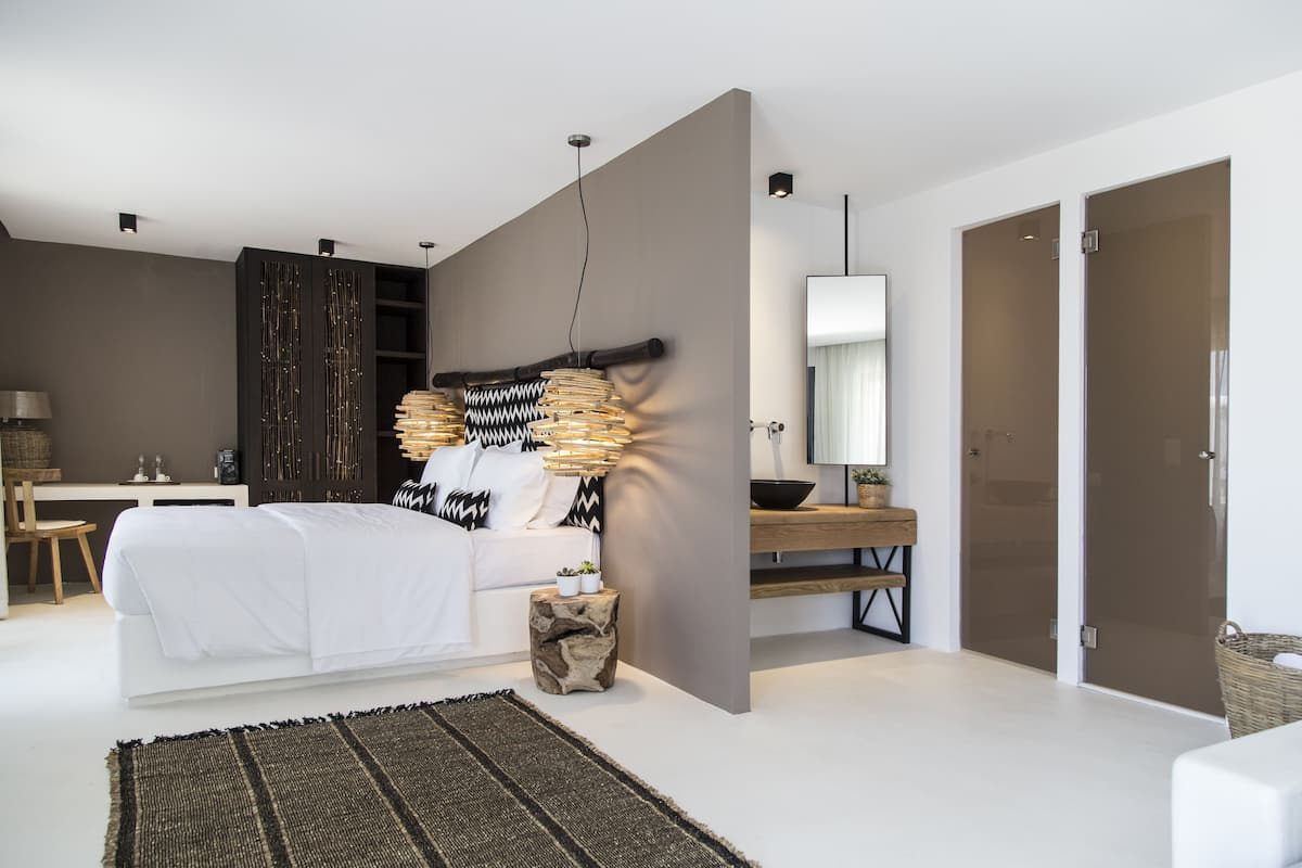 Une chambre à coucher moderne avec un grand lit, un bureau et un miroir.